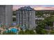Striking building exterior featuring multiple balconies with sunset in the background and a glimpse of the community pool at 13415 Blue Heron Beach Dr # 401, Orlando, FL 32821