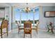 Bright dining area with large windows, stylish light fixture and view of the kitchen bar at 13415 Blue Heron Beach Dr # 401, Orlando, FL 32821