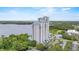 Aerial exterior shot of high-rise condo with pool, lake, and trees at 13415 Blue Heron Beach Dr # 401, Orlando, FL 32821