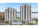 Stunning view of two modern high-rise condos with multiple balconies and a lakeside pool at 13415 Blue Heron Beach Dr # 401, Orlando, FL 32821