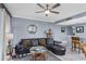 Comfortable living room with a ceiling fan, mirror, and plush leather couch at 13415 Blue Heron Beach Dr # 401, Orlando, FL 32821