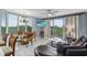 Open-concept living room features a dining table, balcony access, and a modern TV at 13415 Blue Heron Beach Dr # 401, Orlando, FL 32821