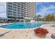 Beautiful community pool featuring a large deck area and a high-rise building in the background at 13415 Blue Heron Beach Dr # 401, Orlando, FL 32821