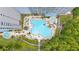 Overhead view of community pool with unique design surrounded by lush landscaping and patio seating areas at 13415 Blue Heron Beach Dr # 401, Orlando, FL 32821