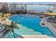 Expansive outdoor pool with ample lounge seating, lush landscaping, and a picturesque lakeside view at 13415 Blue Heron Beach Dr # 401, Orlando, FL 32821