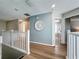 Second floor hallway with wood floors, white railings, and decorative wall art at 1426 Park Park, Haines City, FL 33844