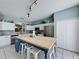 Bright kitchen with white cabinets, stainless steel appliances, butcher block island, and a breakfast bar at 1426 Park Park, Haines City, FL 33844