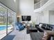 Cozy living room with high ceilings, bright windows with pool views, and staircase access to a second floor at 1426 Park Park, Haines City, FL 33844