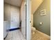 Open view between a laundry room and powder room with bright tile floors and decor at 1426 Park Park, Haines City, FL 33844
