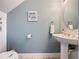 Charming powder room with pedestal sink, oval mirror, and light blue walls at 1426 Park Park, Haines City, FL 33844