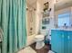 Charming bathroom features a turquoise vanity, and a shower with a patterned curtain, exuding a beachy vibe at 1428 Park Pl, Haines City, FL 33844
