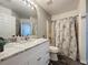 Bathroom boasts a marble countertop vanity, neutral patterned shower curtain and white toilet at 1428 Park Pl, Haines City, FL 33844