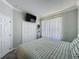 Bright bedroom offers a TV, soft lighting, and storage with a comfortable bed and window at 1428 Park Pl, Haines City, FL 33844