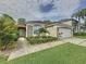 Well-maintained single-story home with a two-car garage and a lush front lawn with tropical landscaping at 1428 Park Pl, Haines City, FL 33844