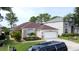Charming single-story home with a two-car garage and a well-maintained front lawn with tropical plants at 1428 Park Pl, Haines City, FL 33844