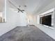 Spacious open-concept living room with plush carpeting, ceiling fan, and a large picture window at 1428 Park Pl, Haines City, FL 33844