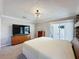 Bright main bedroom showcasing a queen-size bed, neutral color palette, a TV, and outdoor patio access at 1428 Park Pl, Haines City, FL 33844