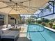 Relaxing screened-in pool area with comfortable lounge furniture and dining set for outdoor entertaining at 1428 Park Pl, Haines City, FL 33844