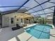 Enjoy this screened-in pool area with ample seating, an umbrella for shade, and a dining area at 1428 Park Pl, Haines City, FL 33844
