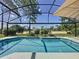 Inviting screened-in pool with clear blue water and views of the golf course beyond at 1428 Park Pl, Haines City, FL 33844