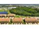 Wide aerial view of the community with yellow townhomes and red-tiled roofs, surrounded by trees and landscaping at 14344 Swanley St, Orlando, FL 32832