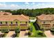 Aerial shot of townhomes boasting well-maintained lawns and brick driveways, set against a backdrop of lush greenery at 14344 Swanley St, Orlando, FL 32832