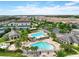 Aerial view of a community pool with palm trees and lounge chairs, plus tennis courts at 14344 Swanley St, Orlando, FL 32832