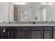 A bathroom showcasing double sinks with granite countertops, dark cabinetry, and a large mirror reflecting the space at 14344 Swanley St, Orlando, FL 32832