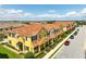 Charming yellow townhomes with orange tile roofs and manicured landscaping offer a welcoming street appeal at 14344 Swanley St, Orlando, FL 32832
