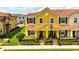 Charming yellow townhouse with a red tile roof, black shutters, and landscaped front yard at 14344 Swanley St, Orlando, FL 32832