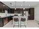 Modern kitchen featuring a granite island, dark cabinetry, stainless steel appliances, and ample lighting at 14344 Swanley St, Orlando, FL 32832