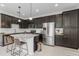 Sleek kitchen showcasing dark cabinets, a granite island with seating, and stainless steel appliances at 14344 Swanley St, Orlando, FL 32832