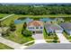 Aerial view of a two-story home with a brick paved driveway, green shutters, and a pond view at 14421 Ward Rd, Orlando, FL 32824
