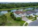 Aerial view of a two-story home with a brick paved driveway, green shutters, and a pond view at 14421 Ward Rd, Orlando, FL 32824