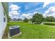 This backyard features green grass, a pond, and a view of the neighboring homes at 14421 Ward Rd, Orlando, FL 32824