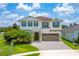 Two-story home with a brick paved driveway, two-car garage, green shutters, and manicured landscaping at 14421 Ward Rd, Orlando, FL 32824