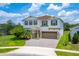 Two-story home featuring neutral paint, green shutters, a brick paved driveway and well-maintained landscaping at 14421 Ward Rd, Orlando, FL 32824