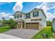 Two-story home featuring neutral paint, green shutters, a brick paved driveway and well-maintained landscaping at 14421 Ward Rd, Orlando, FL 32824