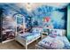 Fun, themed bedroom featuring custom undersea mural and decor with two white twin beds at 1456 Belle Terre Rd, Davenport, FL 33896