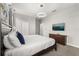 This bedroom features modern decor, a queen bed, and a TV on the wall above a dark wood dresser at 1456 Belle Terre Rd, Davenport, FL 33896