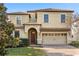 Elegant two-story home featuring a tile roof, arched entryway, and a well-maintained brick paver driveway at 1456 Belle Terre Rd, Davenport, FL 33896