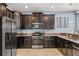 Well-equipped kitchen with stainless steel appliances, dark cabinetry, and granite countertops at 1456 Belle Terre Rd, Davenport, FL 33896