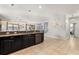 Open-concept kitchen with modern appliances and a breakfast bar, flowing into the staircase and hallway at 1456 Belle Terre Rd, Davenport, FL 33896