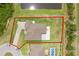 Aerial view of the property, outlined in red, showcases the land and proximity to pond at 1504 Cordgrass Way, Lakeland, FL 33813