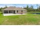 View of the backyard with a patio, outdoor furniture, and a well-maintained lawn extending to a pond at 1504 Cordgrass Way, Lakeland, FL 33813