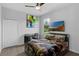 Cozy bedroom with a ceiling fan, large window, and a themed bed set, creating a comfortable space at 1504 Cordgrass Way, Lakeland, FL 33813