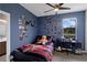 Comfortable bedroom featuring a ceiling fan, wood floors, and unique decor at 1504 Cordgrass Way, Lakeland, FL 33813