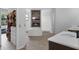 Modern bathroom featuring double sinks, closet, bathtub with brick accent wall, and walk-in shower at 1504 Cordgrass Way, Lakeland, FL 33813