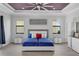 Spacious bedroom features tray ceilings, ceiling fan, wood floors, and white furniture at 1504 Cordgrass Way, Lakeland, FL 33813