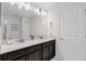 Bright bathroom featuring double sinks, sleek countertops, and a large well-lit mirror at 1560 Maidstone Ct, Davenport, FL 33896